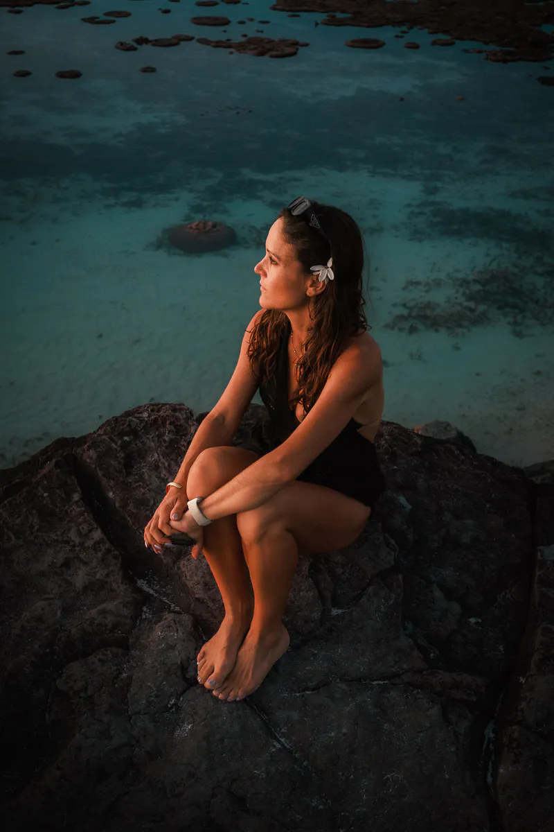 Sam sitting in the sunset at Black Rock, Rarotonga